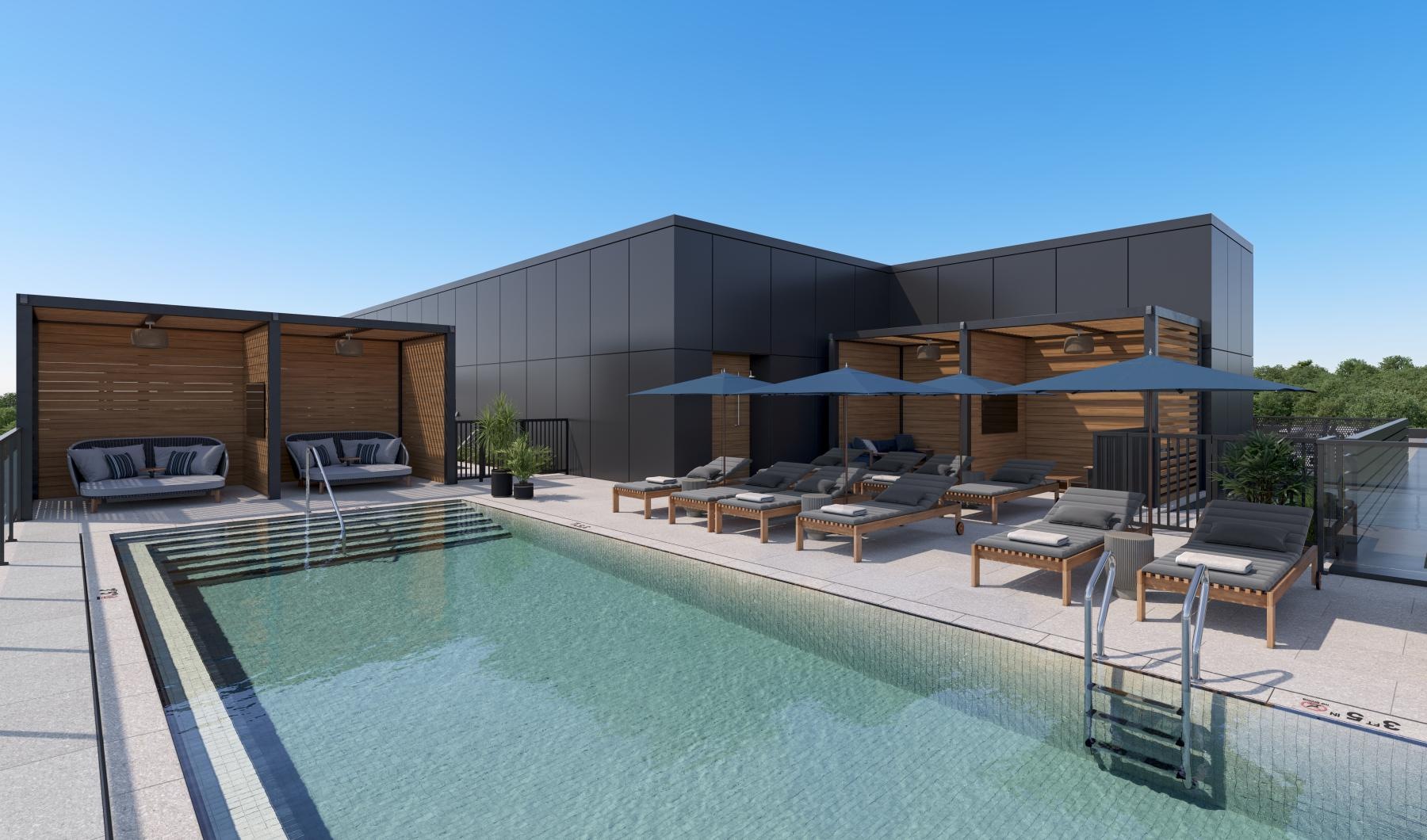 a swimming pool with chairs and umbrellas next to a building