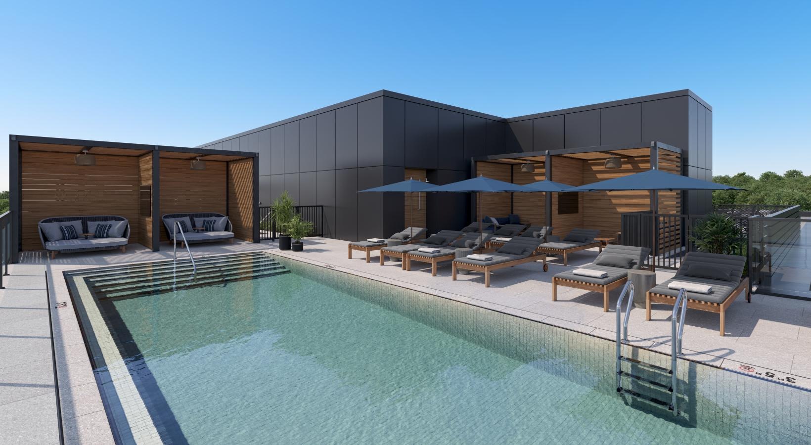 a swimming pool with chairs and umbrellas next to a building